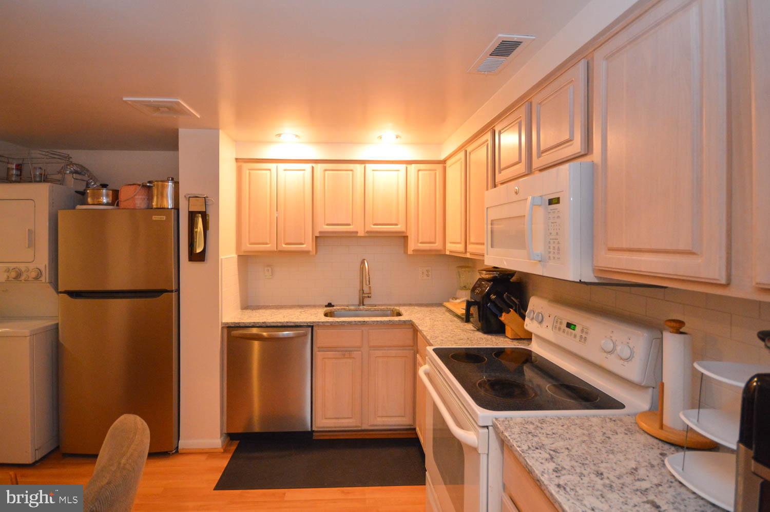 6317 Park Heights Avenue, Unit 310 Baltimore, MD 21215 - Photo 24 of 37 a kitchen with a refrigerator sink and cabinets