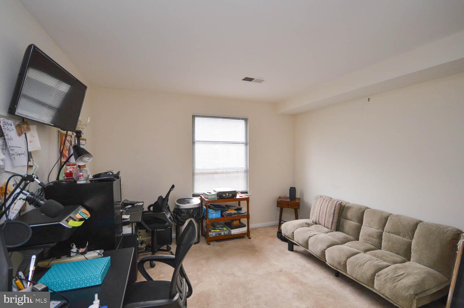 6317 Park Heights Avenue, Unit 310 Baltimore, MD 21215 - Photo 26 of 37 a living room with furniture and a flat screen tv