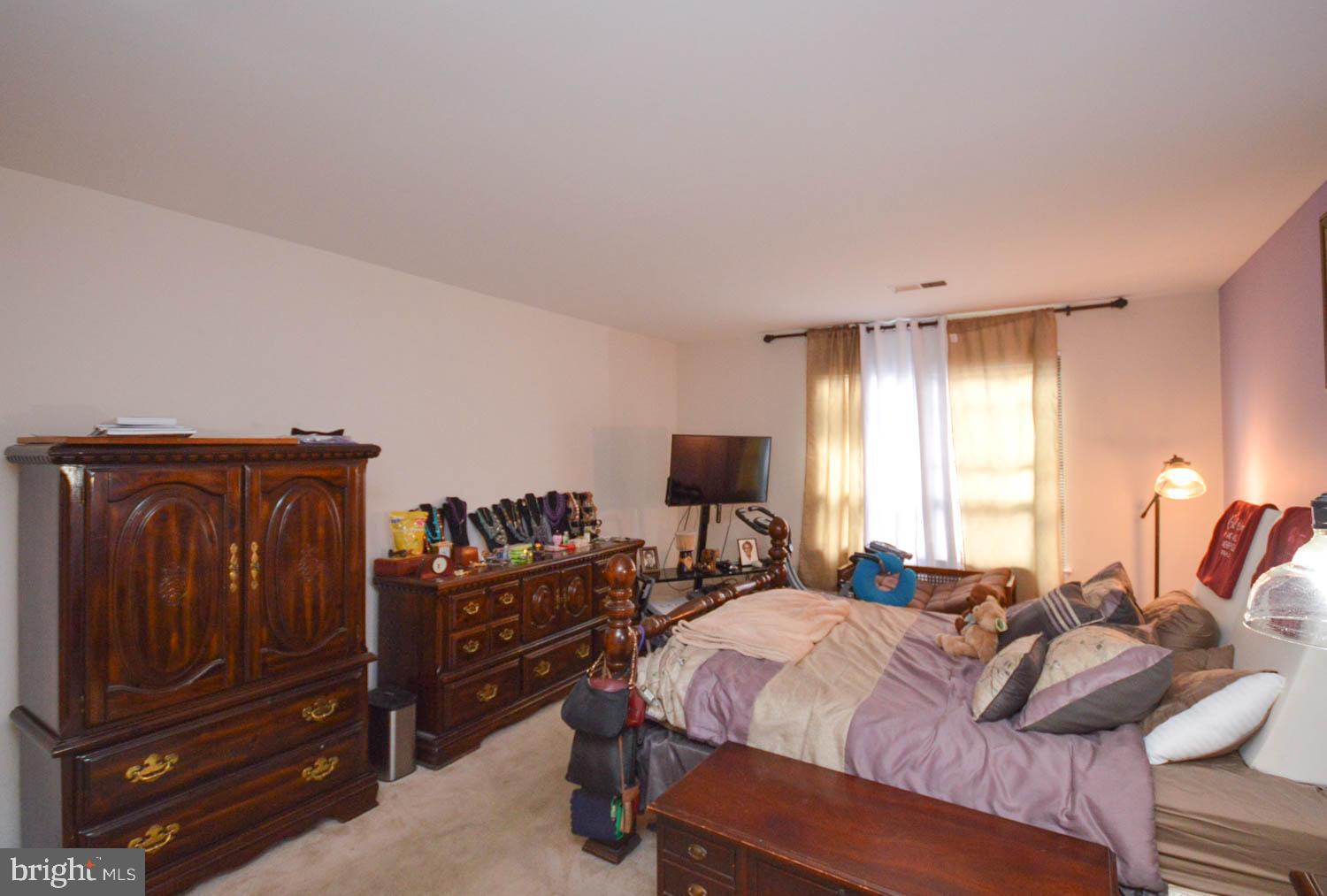 6317 Park Heights Avenue, Unit 310 Baltimore, MD 21215 - Photo 32 of 37 a bedroom with a bed and wooden floor