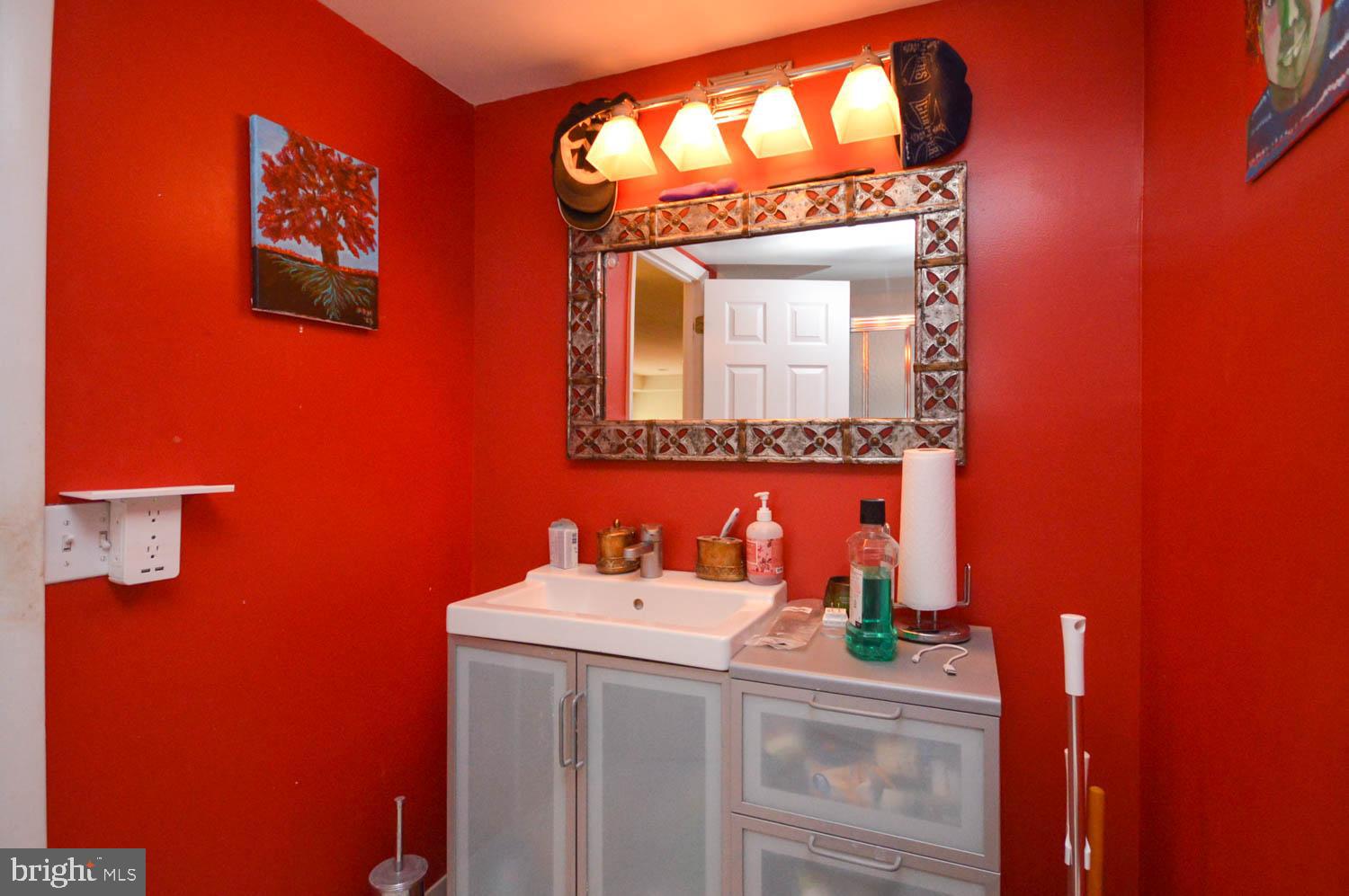 6317 Park Heights Avenue, Unit 310 Baltimore, MD 21215 - Photo 36 of 37 a bathroom with a sink and a mirror