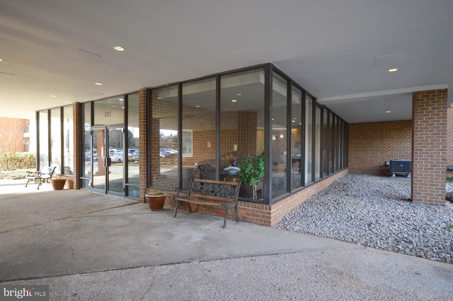 6317 Park Heights Avenue, Unit 310 Baltimore, MD 21215 - Photo 4 of 37 a view of an empty room with floor to ceiling window and palm tree