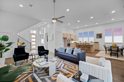 a living room with furniture kitchen view and a chandelier