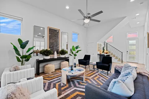 a living room with furniture a chandelier and a potted plant