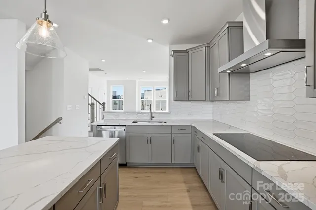 a large kitchen with kitchen island a large island a sink stainless steel appliances and cabinets