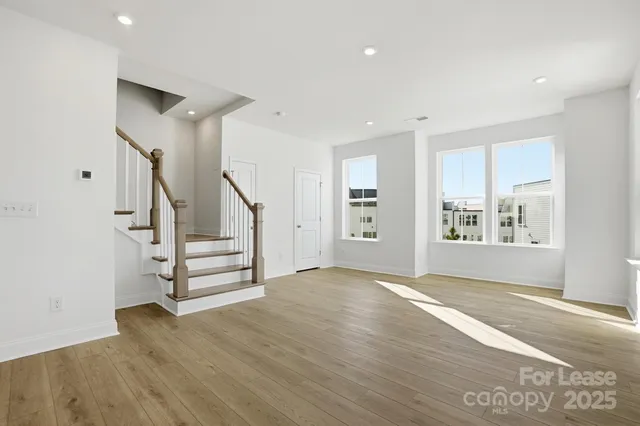 a view of an empty room with wooden floor and entryway