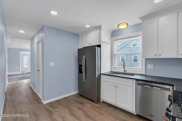 a kitchen with white cabinets and appliances