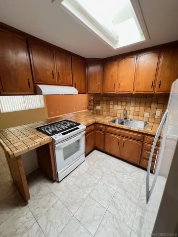 a kitchen with a sink a refrigerator and cabinets