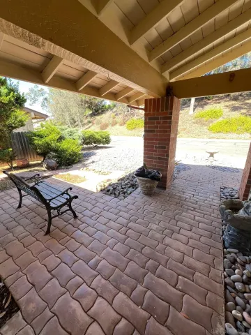 a view of a balcony with wooden floor and a large tree