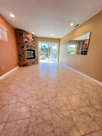 a view of an empty room with a fireplace and a window