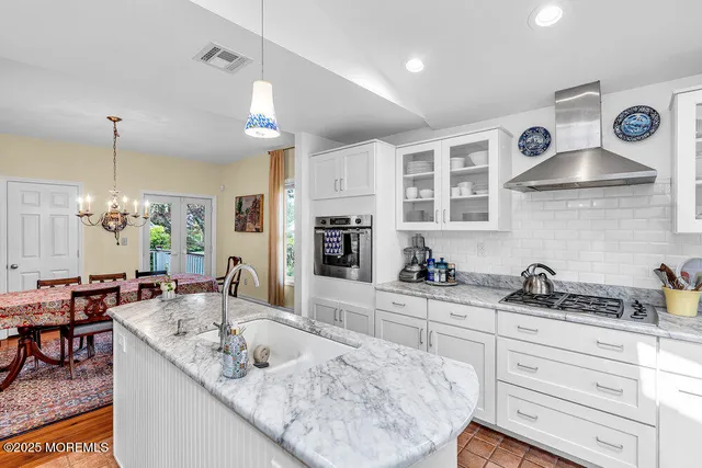 a kitchen with granite countertop a sink a stove and cabinets