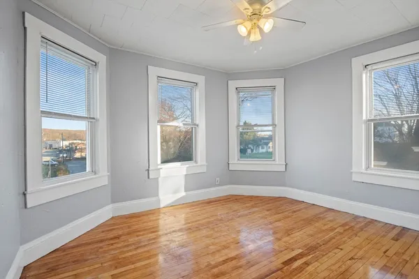 a view of empty room with window and wooden floor