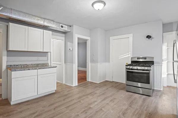 a kitchen with granite countertop a stove and a refrigerator