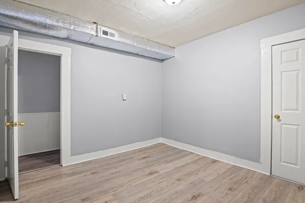 a view of a small space with wooden floor and closet