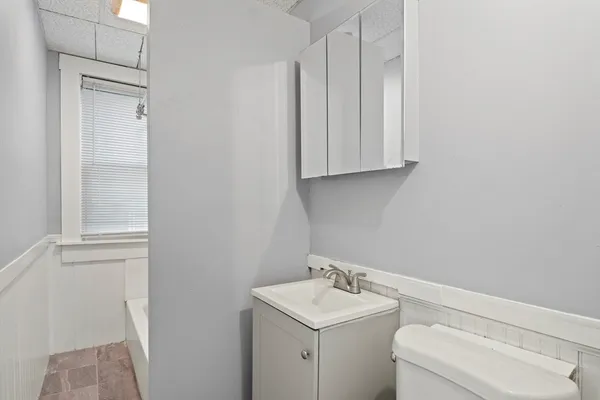 a bathroom with a toilet a sink and a window