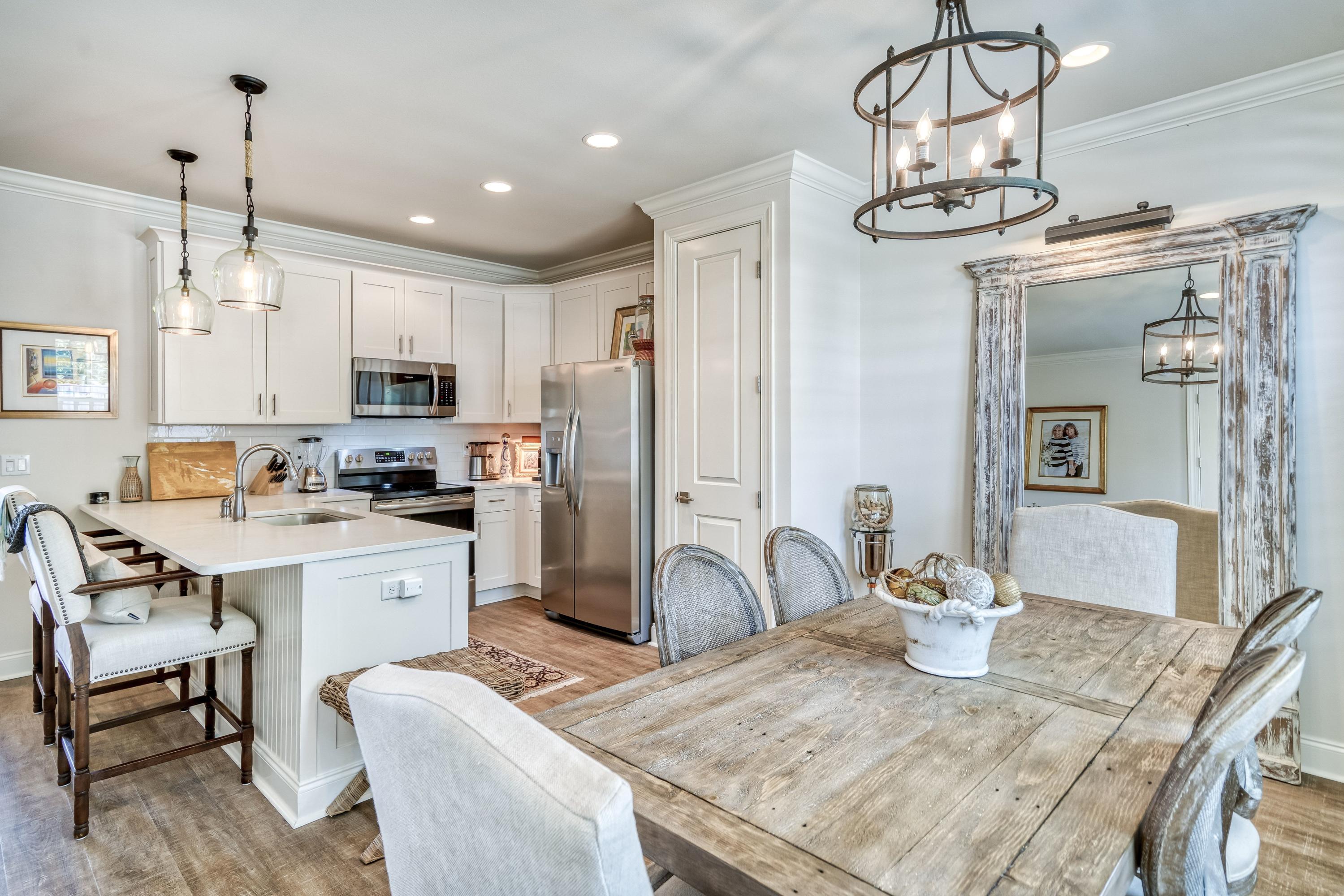 80 North Zander Way Santa Rosa Beach, FL 32459 - Photo 21 of 49 a kitchen with kitchen island granite countertop a table and chairs in it