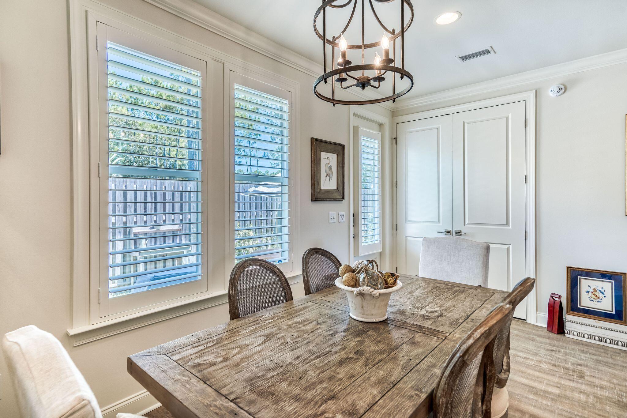 80 North Zander Way Santa Rosa Beach, FL 32459 - Photo 23 of 49 a view of a dining room with furniture a chandelier and wooden floor