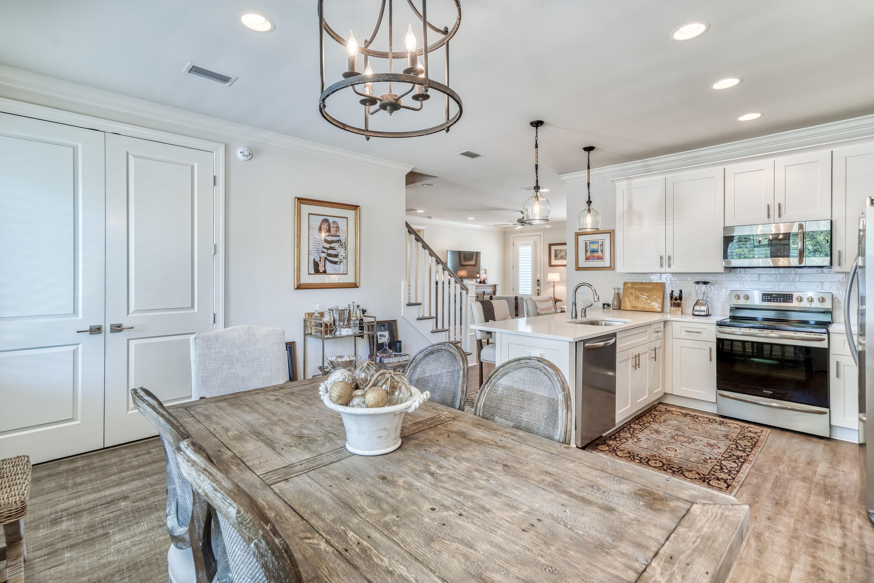 80 North Zander Way Santa Rosa Beach, FL 32459 - Photo 24 of 49 a kitchen with a table chairs and white cabinets