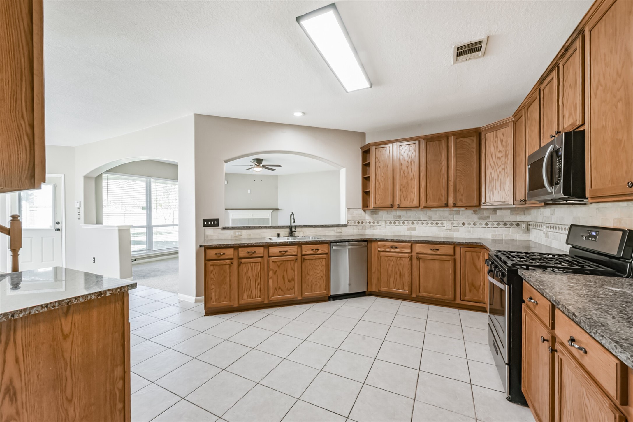 3919 Copper Creek Baytown, TX 77521 - Photo 11 of 50 a open kitchen with granite countertop a sink stove top oven and cabinets