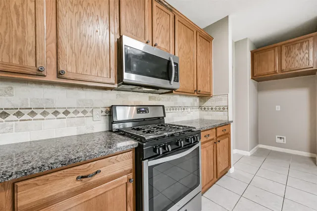 a kitchen with stainless steel appliances granite countertop a stove a microwave and a sink
