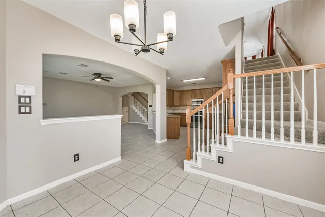 a view of a hallway with entryway and chandelier