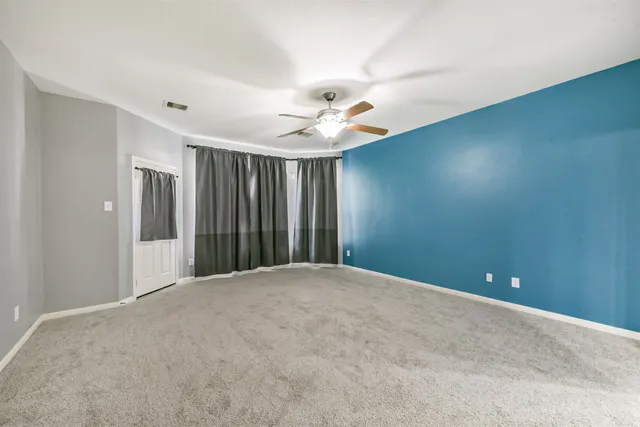 a view of a livingroom with a ceiling fan and window