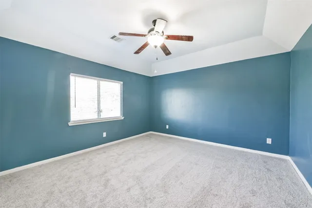 an empty room with windows and fan