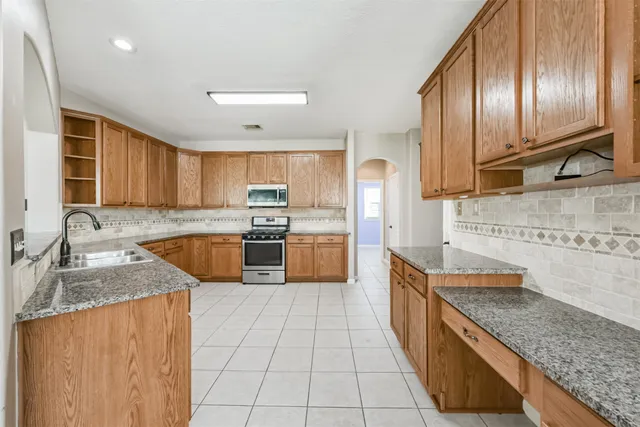 a kitchen with stainless steel appliances granite countertop a sink stove and refrigerator