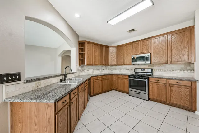 a kitchen with stainless steel appliances granite countertop a stove sink microwave and cabinets