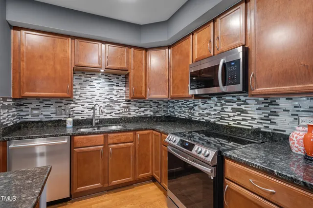 a kitchen with stainless steel appliances wooden cabinets and a stove top oven