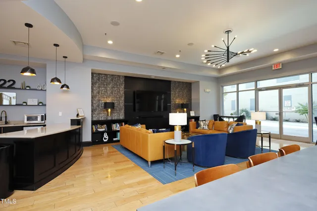 a living room with furniture kitchen view and a large window