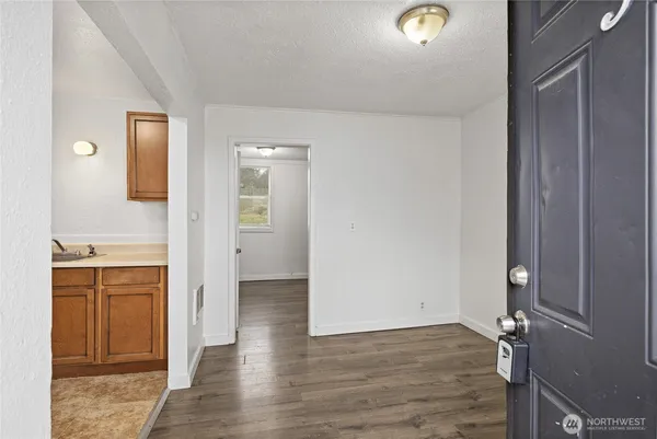 a view of a kitchen from the hallway with a sink