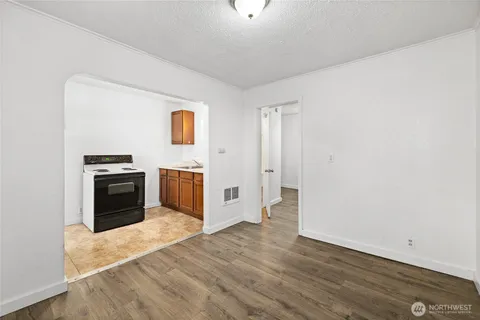 a view of a kitchen with a sink stove cabinets and empty room