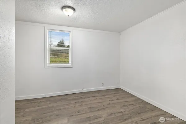 an empty room with wooden floor and window