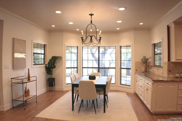 a large kitchen with stainless steel appliances a stove a sink dishwasher and a refrigerator with wooden floor