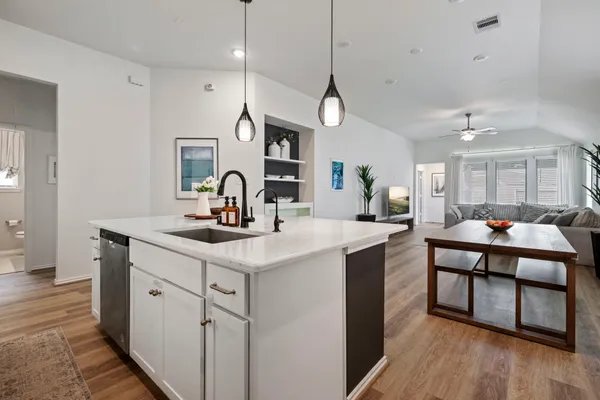 a kitchen with kitchen island a sink and a stove top oven
