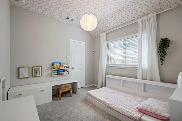 a bedroom with a bed and a chandelier