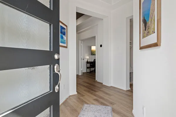 a view of a hallway view with wooden floor and living room