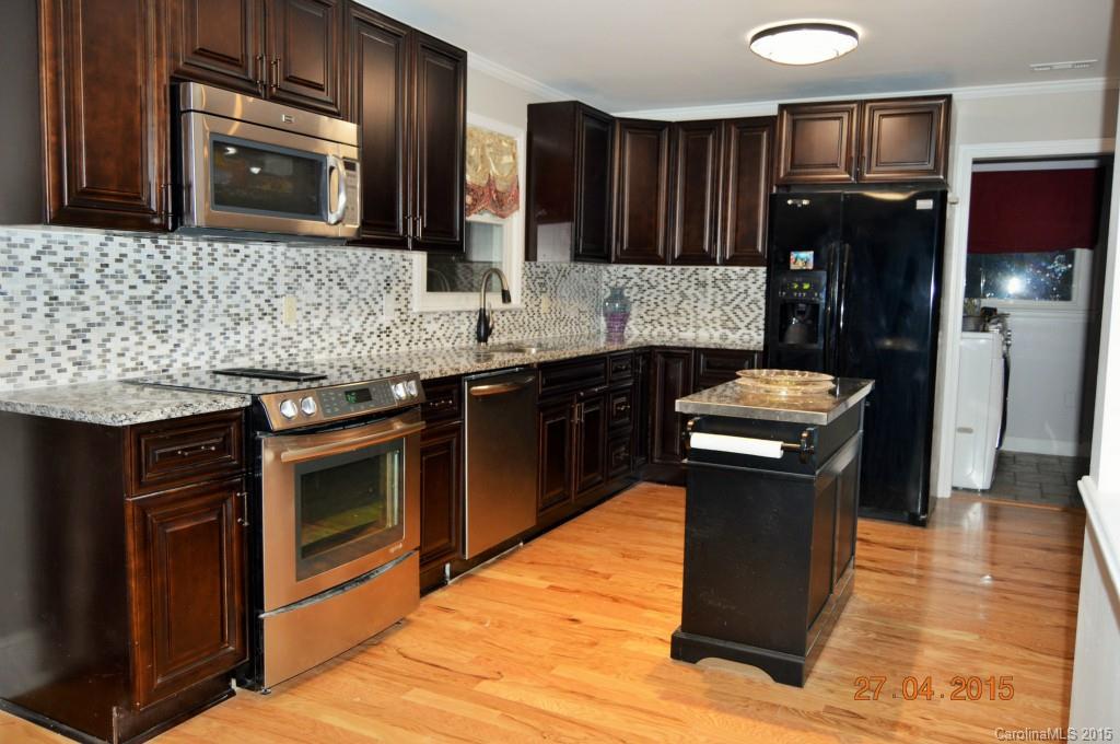 10060 Unity Church Road Mooresville, NC 28115 - Photo 2 of 22 a kitchen with granite countertop stainless steel appliances and wooden cabinets