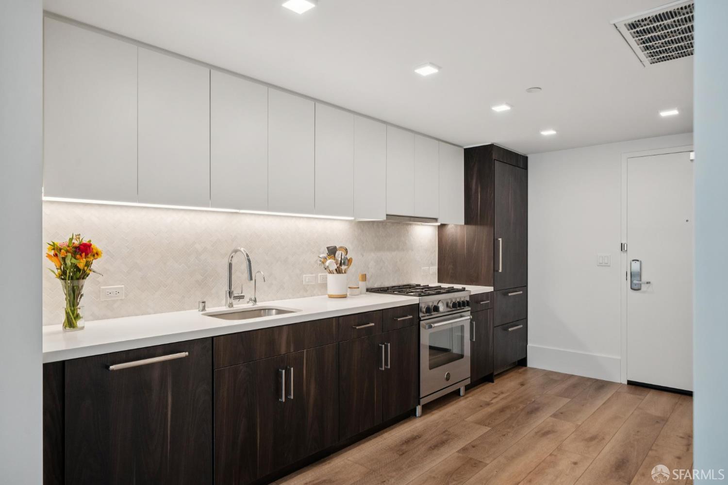 1288 Howard Street, Unit 317 San Francisco, CA 94103 - Photo 11 of 57 a kitchen with stainless steel appliances a sink stove and cabinets