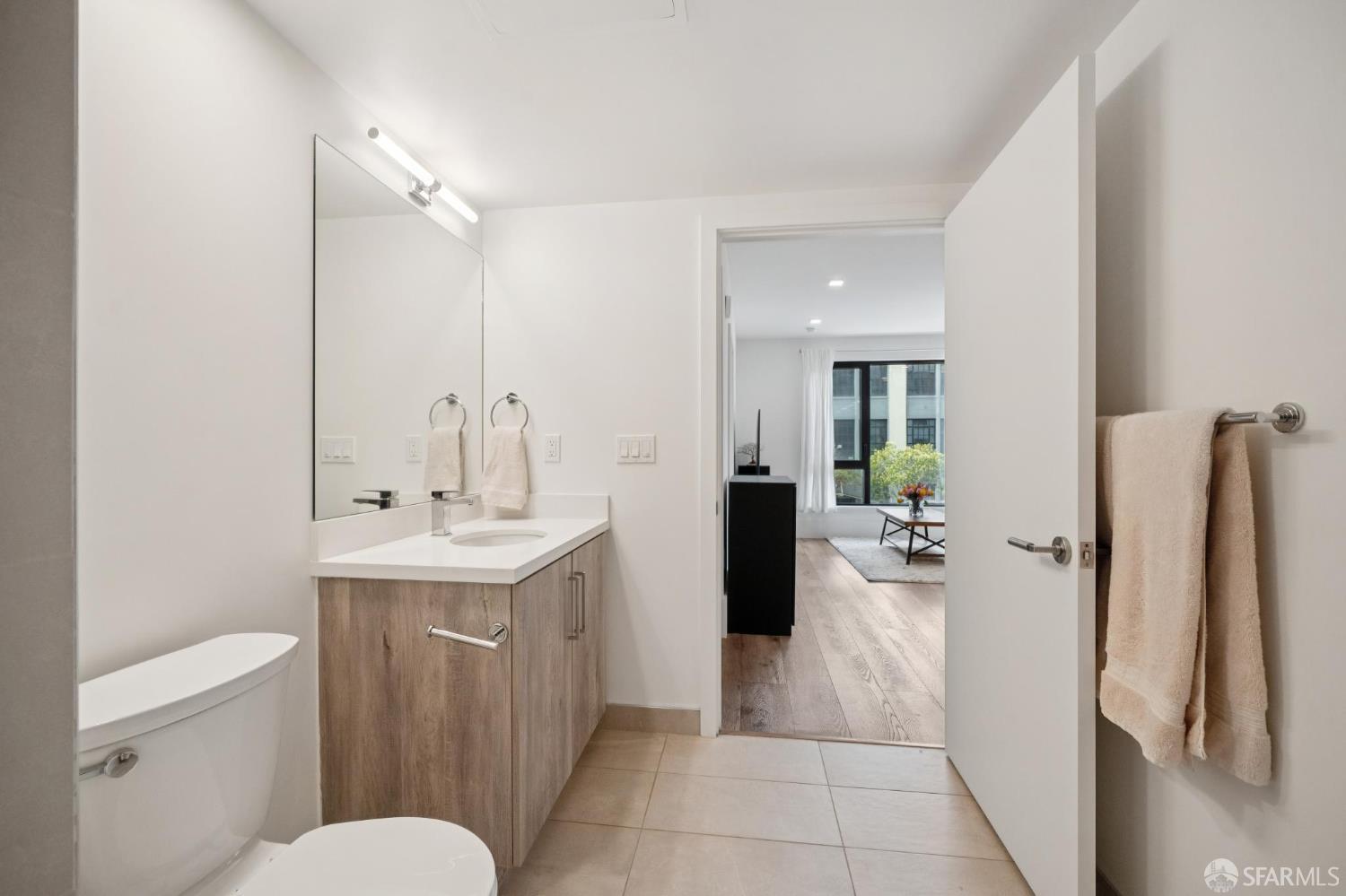 1288 Howard Street, Unit 317 San Francisco, CA 94103 - Photo 22 of 57 a bathroom with a sink a toilet and mirror