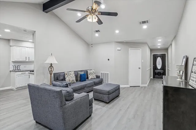 a living room with furniture and a ceiling fan