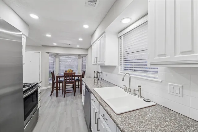 a kitchen with stainless steel appliances granite countertop a sink stove and cabinets