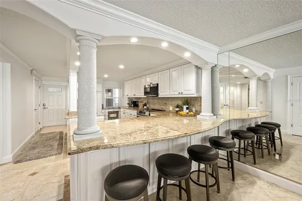 a dining room with furniture a rug and kitchen view