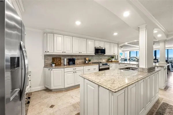 a kitchen with stainless steel appliances granite countertop a stove a sink and a microwave