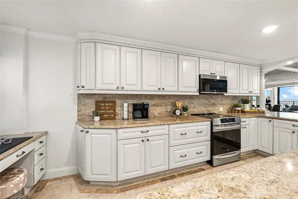 a kitchen with stainless steel appliances granite countertop a stove a sink and a microwave