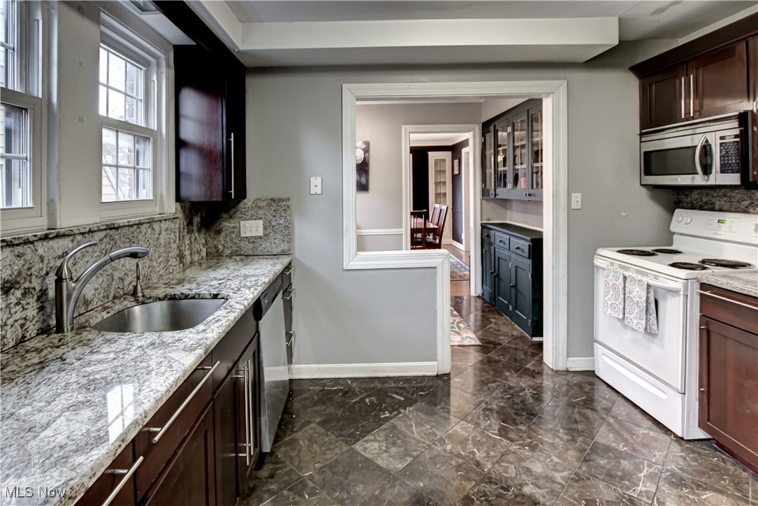 17800 Winslow Road Beachwood, OH 44122 - Photo 4 of 31 Kitchen with sink, light stone countertops, stainless steel appliances, and tasteful backsplash