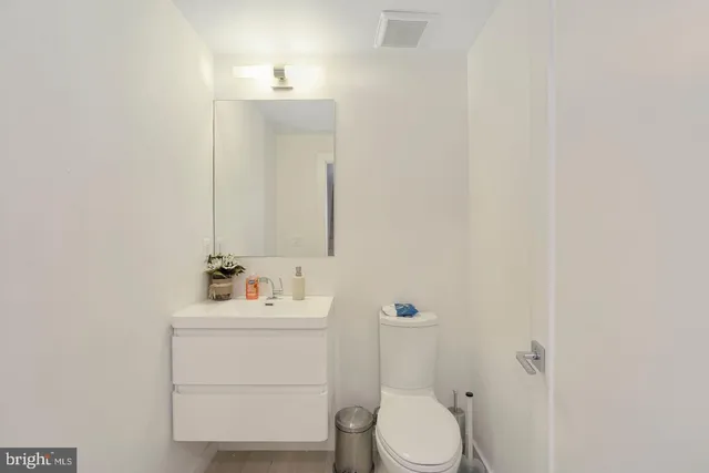 a bathroom with a sink vanity mirror and toilet