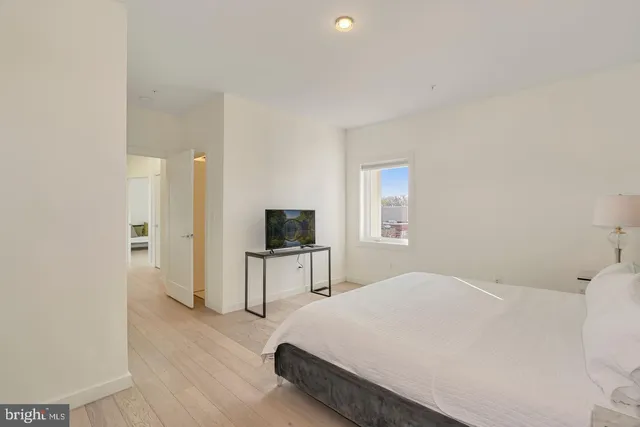 a bedroom with a bed and a flat screen tv