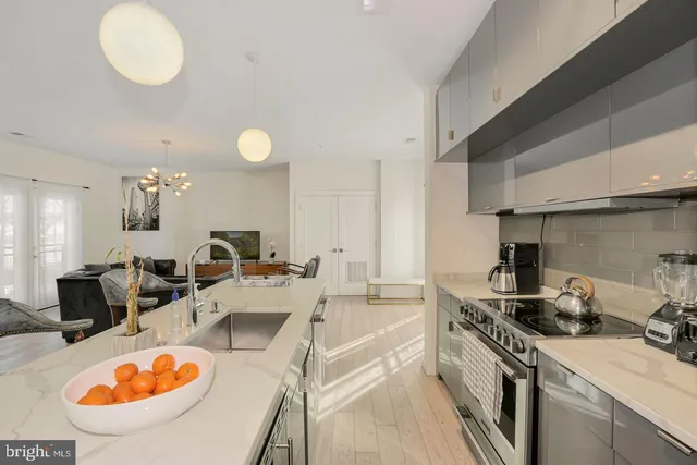 a kitchen with stainless steel appliances granite countertop a sink a stove and a wooden floors