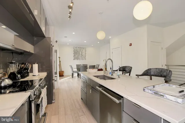 a kitchen with lots of counter space and view of living room